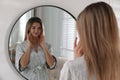 Beautiful young woman near mirror in room Royalty Free Stock Photo