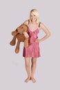 Beautiful young woman in nightie with teddy bear