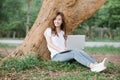 Beautiful young woman using laptop sitting in the park Royalty Free Stock Photo