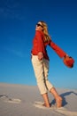 Beautiful young woman, with open arms, is walking along desert Royalty Free Stock Photo