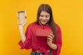 Beautiful young woman with an open gift box and looks admiringly into it. Girl received gift. Yellow background