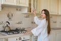 A beautiful young woman is opening a kitchen cabinet Royalty Free Stock Photo