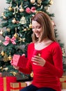 Beautiful young woman opening a Christmas present Royalty Free Stock Photo