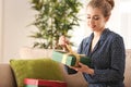 Beautiful young woman opening gift box at home Royalty Free Stock Photo