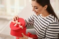 Beautiful young woman opening gift box at home Royalty Free Stock Photo