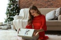 Beautiful young woman opening gift box at home Royalty Free Stock Photo