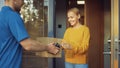 Beautiful Young Woman Opens Doors of Her House and Meets Delivery Man who Gives Her Cardboard Box Royalty Free Stock Photo