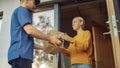 Beautiful Young Woman Opens Doors of Her House and Meets Delivery Man who Gives Her Cardboard Box Royalty Free Stock Photo