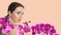 Beautiful young woman and orchid flowers on light background, space for text. Spa portrait Royalty Free Stock Photo