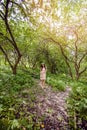 Beautiful young woman outdoors. Beauty girl brunette in white flowers wreath in hair walking in spring blossom garden Royalty Free Stock Photo