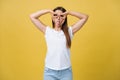 Beautiful young woman over yellow background happy face smiling doing ok or glass sign with hand on eye looking through Royalty Free Stock Photo