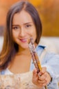 Beautiful young woman painter with paint brush in hands, in a blurred background