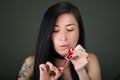 Beautiful young woman painting her nails with red lacquer Royalty Free Stock Photo