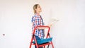 Portrait of beautiful young woman painting walls with paint roller Royalty Free Stock Photo