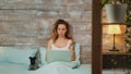 Beautiful young woman in pajamas working on laptop Royalty Free Stock Photo