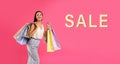 Beautiful young woman with paper shopping bags and word SALE on pink background. Banner design Royalty Free Stock Photo