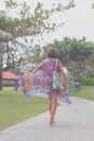 Beautiful young woman in pareo and swimsuit walking in the becah park with bag on sunny summer day. Tropical island Bali Royalty Free Stock Photo