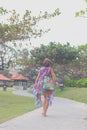 Beautiful young woman in pareo and swimsuit walking in the becah park with bag on sunny summer day. Tropical island Bali Royalty Free Stock Photo