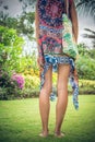 Beautiful young woman in pareo and swimsuit walking in the becah park with bag on sunny summer day. Tropical island Bali, Indonesi Royalty Free Stock Photo