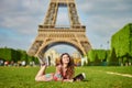 Beautiful young woman in Paris lying on the grass near the Eiffel tower Royalty Free Stock Photo