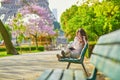 Beautiful young woman in Paris reading on the bench Royalty Free Stock Photo