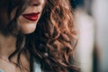 Beautiful young woman with perfect dark curly hair and beautiful make-up with puffy red lips. Close-up. Soft selective focus