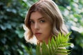 Beautiful young woman with perfect skin  posing front of plant tropical green leaves background with fern Royalty Free Stock Photo