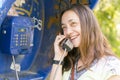 Beautiful young woman in a phone booth. The girl is talking on the phone from the payphone. pretty woman talking by public Royalty Free Stock Photo