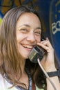 Beautiful young woman in a phone booth. The girl is talking on the phone from the payphone. woman talking by public telephone Royalty Free Stock Photo