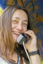 Beautiful young woman in a phone booth. The girl is talking on the phone from the payphone. woman talking by public telephone Royalty Free Stock Photo