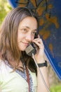 Beautiful young woman in a phone booth. The girl is talking on the phone from the payphone. woman talking by public telephone Royalty Free Stock Photo