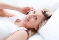 Beautiful young woman on phone lying on her bed Royalty Free Stock Photo
