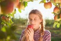 Beautiful young woman picking ripe organic apples