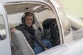 Beautiful Young Woman Pilot With Headset Sitting in Cabin of Modern Aircraft Royalty Free Stock Photo