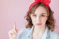 Beautiful young woman with pin-up make-up and hairstyle. Studio shot on pink background Royalty Free Stock Photo