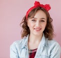 Beautiful young woman with pin-up make-up and hairstyle. Studio shot on pink background Royalty Free Stock Photo