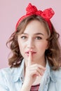 Beautiful young woman with pin-up make-up and hairstyle. Studio shot on pink background Royalty Free Stock Photo