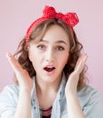 Beautiful young woman with pin-up make-up and hairstyle. Studio shot on pink background Royalty Free Stock Photo