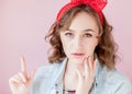 Beautiful young woman with pin-up make-up and hairstyle. Studio shot on pink background Royalty Free Stock Photo