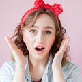 Beautiful young woman with pin-up make-up and hairstyle. Studio shot on pink background Royalty Free Stock Photo