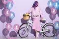 beautiful young woman in pink clothing on bicycle with pineapple and bananas
