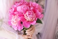 Beautiful young woman in pink dress holding peony flowers bouquet in her hands Royalty Free Stock Photo