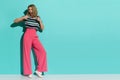Stylish Woman In Pink Wide Legs Trousers, Sneakers And Striped Blouse Is Showing Thumbs Up