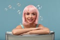 Beautiful young woman with pink wig and bright make-up in soap bubbles. Fashion model girl with creative color makeup Royalty Free Stock Photo