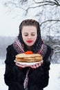 Woman with a plate of pancakes and red caviar