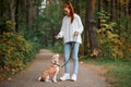 Beautiful young woman with playful young dog having fun outdoors