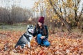 Beautiful young woman playing with her dog in autumn park Royalty Free Stock Photo