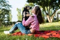 Beautiful young woman playing with her young dog in the park outdoors. Life style portrait. Royalty Free Stock Photo