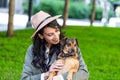 Beautiful young woman playing with her dogin a park outdoors. Lifestyle portrait. Cute young woman hugs her puppy dog. Love Royalty Free Stock Photo