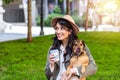 Beautiful young woman playing with her dogin a park outdoors. Lifestyle portrait. happy hipster woman playing with her dog and Royalty Free Stock Photo